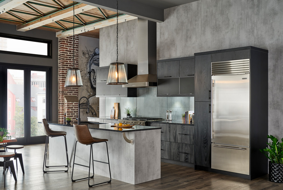 Inspiration for a medium sized urban single-wall kitchen/diner in New York with a submerged sink, flat-panel cabinets, black cabinets, composite countertops, grey splashback, glass sheet splashback, stainless steel appliances, an island, brown floors and black worktops.