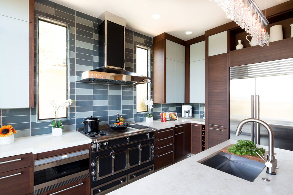 Example of a mid-sized minimalist u-shaped medium tone wood floor kitchen pantry design in Los Angeles with an undermount sink, flat-panel cabinets, dark wood cabinets, multicolored backsplash, ceramic backsplash, stainless steel appliances and an island
