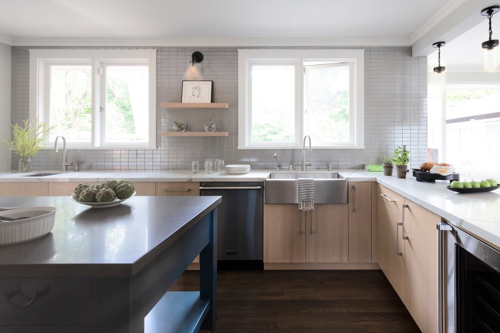 Kitchen - large transitional u-shaped brown floor and dark wood floor kitchen idea in San Francisco with a farmhouse sink, flat-panel cabinets, light wood cabinets, quartz countertops, gray backsplash, ceramic backsplash, stainless steel appliances, an island and white countertops