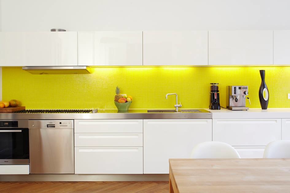 This is an example of a large modern single-wall kitchen/diner in Miami with a submerged sink, flat-panel cabinets, white cabinets, yellow splashback, mosaic tiled splashback, stainless steel appliances, light hardwood flooring and an island.
