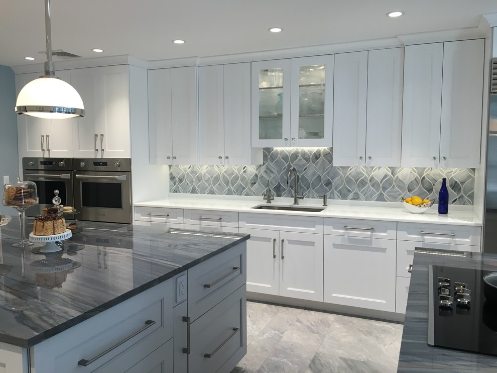 Huge trendy u-shaped ceramic tile eat-in kitchen photo in New York with a single-bowl sink, shaker cabinets, white cabinets, quartzite countertops, gray backsplash, glass sheet backsplash, stainless steel appliances and two islands