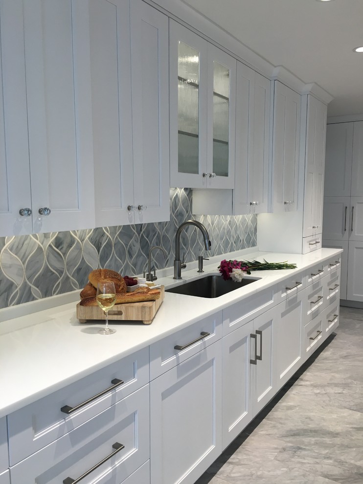 Eat-in kitchen - huge contemporary u-shaped ceramic tile eat-in kitchen idea in New York with a single-bowl sink, shaker cabinets, white cabinets, quartzite countertops, gray backsplash, glass sheet backsplash, stainless steel appliances and two islands