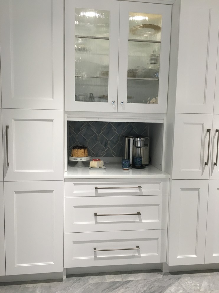 Eat-in kitchen - huge contemporary u-shaped ceramic tile eat-in kitchen idea in New York with a single-bowl sink, shaker cabinets, white cabinets, quartzite countertops, gray backsplash, glass sheet backsplash, stainless steel appliances and two islands