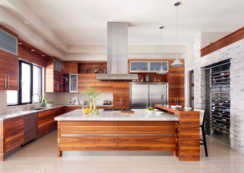 This is an example of a large modern l-shaped kitchen in Montreal with a single-bowl sink, flat-panel cabinets, medium wood cabinets, marble worktops, stainless steel appliances, porcelain flooring, an island and beige floors.
