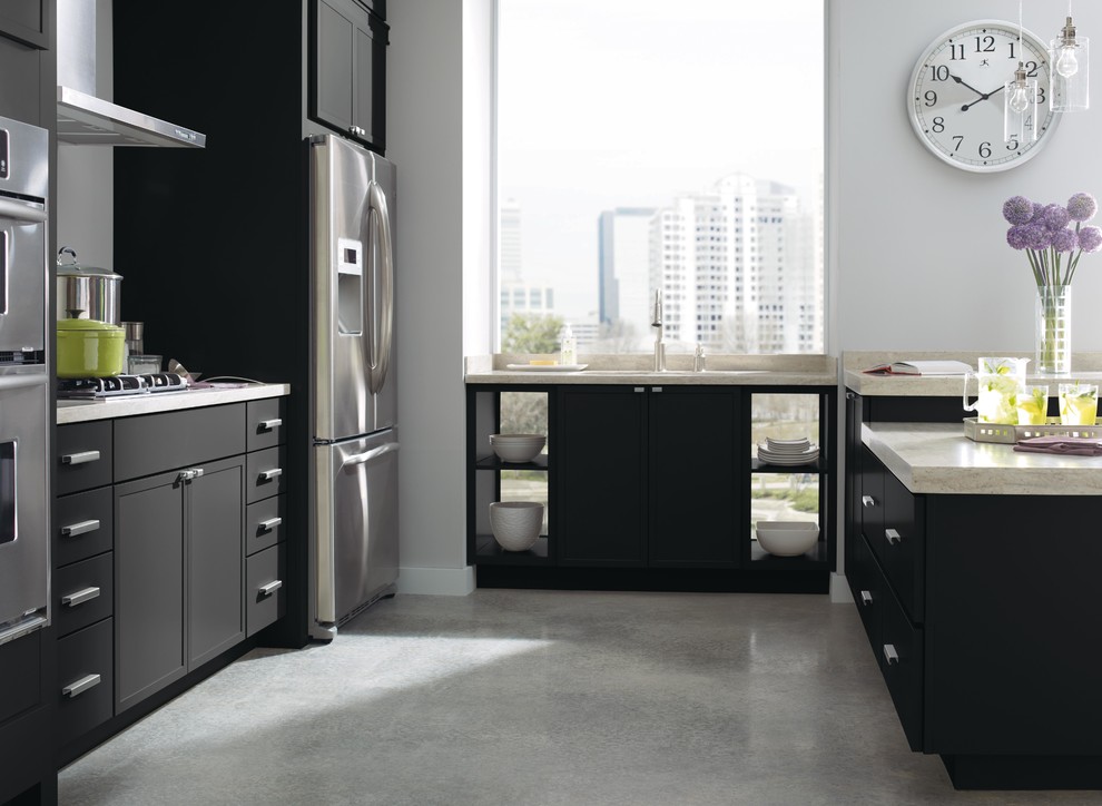 Kleine Moderne Wohnküche in U-Form mit Schrankfronten mit vertiefter Füllung, schwarzen Schränken, Mineralwerkstoff-Arbeitsplatte, Küchengeräten aus Edelstahl und Kücheninsel in New York