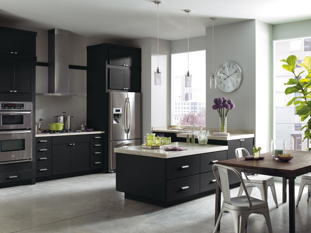 Eat-in kitchen - small modern u-shaped eat-in kitchen idea in New York with recessed-panel cabinets, black cabinets, solid surface countertops, stainless steel appliances and an island