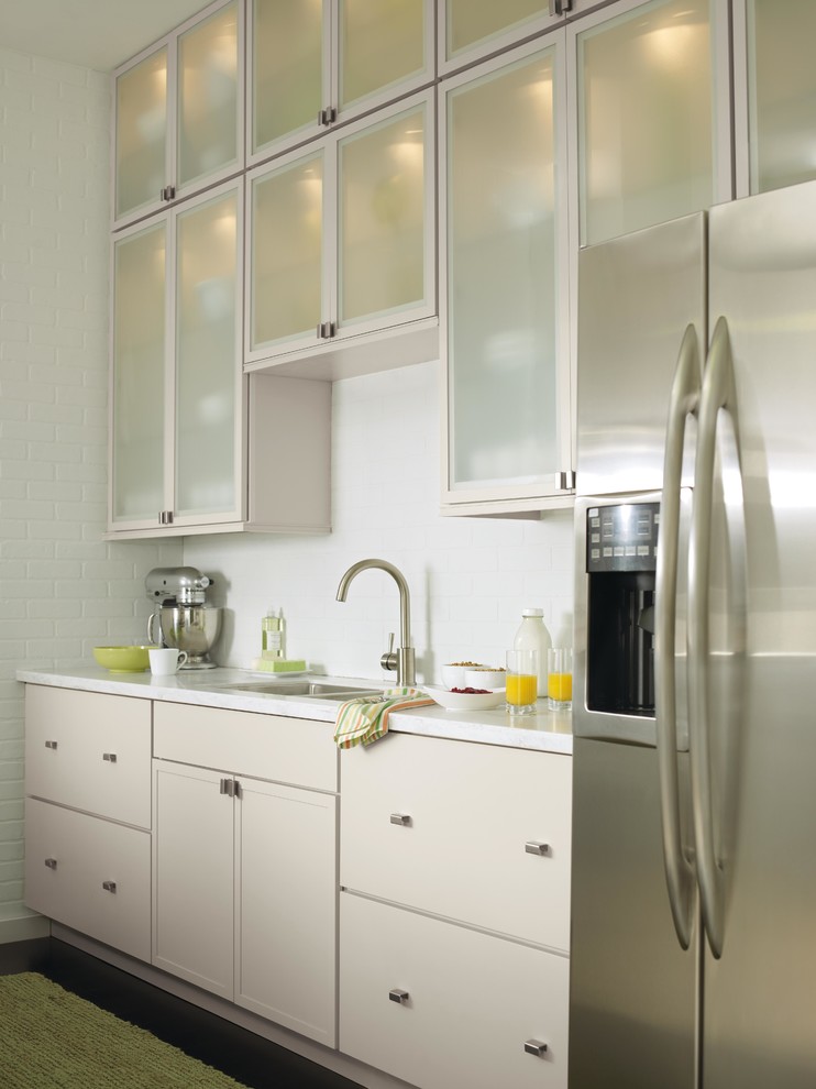 Immagine di una cucina minimalista di medie dimensioni con ante lisce, ante grigie, top in superficie solida e elettrodomestici in acciaio inossidabile