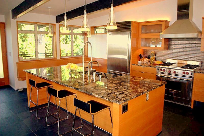Modern inredning av ett mellanstort kök och matrum, med släta luckor, skåp i ljust trä, granitbänkskiva, flerfärgad stänkskydd, rostfria vitvaror, klinkergolv i keramik, en köksö och svart golv