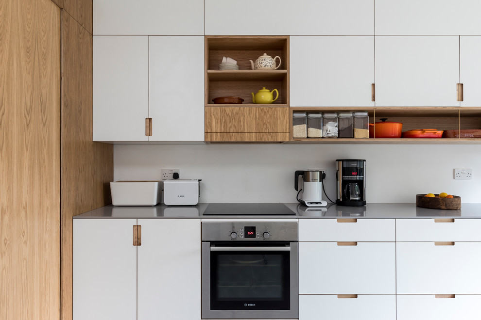 Cette image montre une cuisine américaine linéaire minimaliste de taille moyenne avec un plan de travail en quartz modifié.