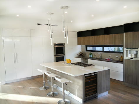 Modern l-shaped open plan kitchen in Los Angeles with stainless steel appliances, medium hardwood flooring and an island.