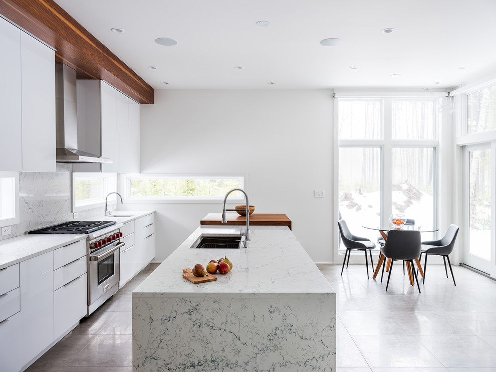 Mid-sized minimalist single-wall ceramic tile and beige floor eat-in kitchen photo in Burlington with a drop-in sink, flat-panel cabinets, dark wood cabinets, marble countertops, white backsplash, marble backsplash, stainless steel appliances, an island and gray countertops