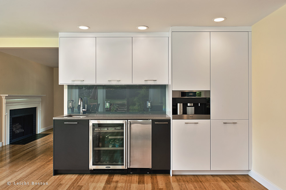 Eat-in kitchen - large contemporary u-shaped light wood floor eat-in kitchen idea in Boston with an undermount sink, flat-panel cabinets, white cabinets, quartz countertops, gray backsplash, glass sheet backsplash, stainless steel appliances and an island