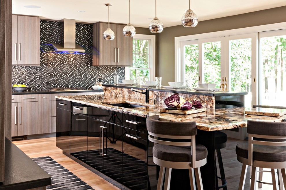 Eat-in kitchen - mid-sized transitional l-shaped medium tone wood floor eat-in kitchen idea in Boston with an undermount sink, flat-panel cabinets, gray cabinets, granite countertops, black backsplash, mosaic tile backsplash, paneled appliances and an island