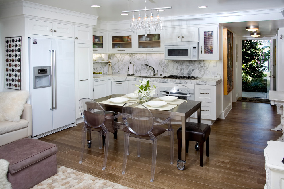 Example of a beach style kitchen design in Orange County with raised-panel cabinets, white cabinets, white backsplash, stone slab backsplash and white appliances