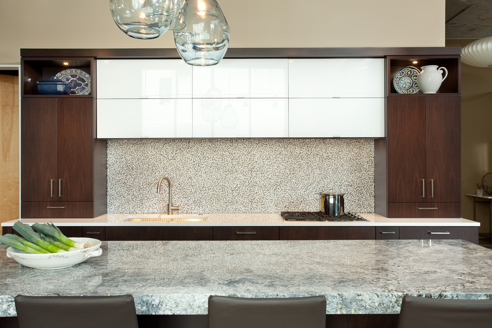 Inspiration for a mid-sized modern l-shaped concrete floor open concept kitchen remodel in Minneapolis with an undermount sink, flat-panel cabinets, dark wood cabinets, granite countertops, white backsplash, glass tile backsplash, paneled appliances and an island