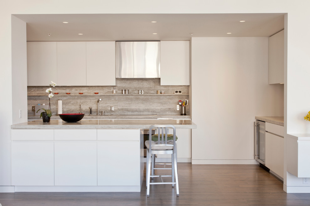 Minimalist u-shaped kitchen photo in Minneapolis with an undermount sink, flat-panel cabinets, white cabinets, stone slab backsplash and stainless steel appliances
