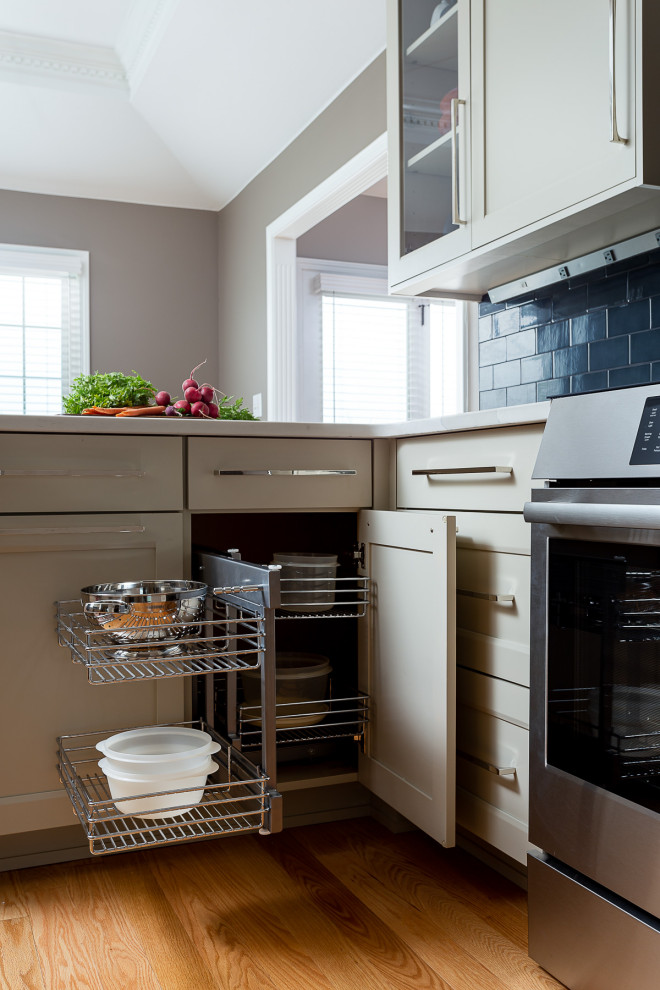 ルイビルにある高級な中くらいなコンテンポラリースタイルのおしゃれなキッチン (アンダーカウンターシンク、フラットパネル扉のキャビネット、濃色木目調キャビネット、クオーツストーンカウンター、青いキッチンパネル、セラミックタイルのキッチンパネル、シルバーの調理設備、無垢フローリング、白いキッチンカウンター、折り上げ天井) の写真