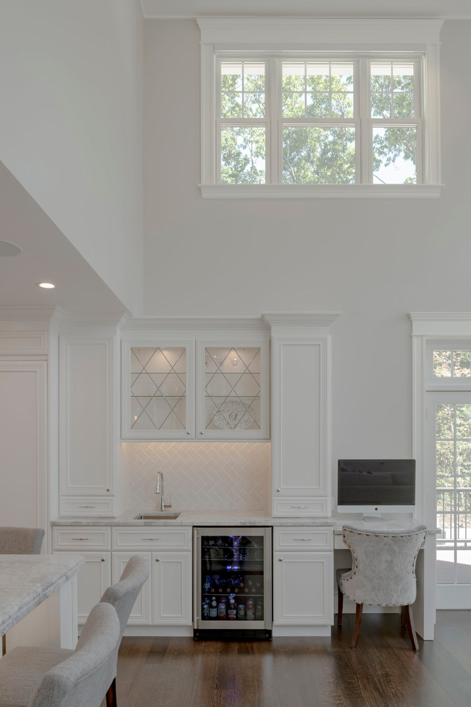 Bild på ett stort funkis kök, med en undermonterad diskho, luckor med profilerade fronter, vita skåp, marmorbänkskiva, vitt stänkskydd, stänkskydd i keramik, rostfria vitvaror, mörkt trägolv, en köksö och brunt golv