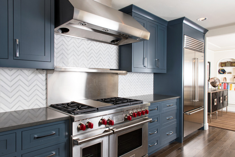 Idéer för ett mellanstort klassiskt kök, med en undermonterad diskho, luckor med infälld panel, blå skåp, bänkskiva i zink, vitt stänkskydd, stänkskydd i keramik, rostfria vitvaror, mellanmörkt trägolv, en halv köksö och brunt golv