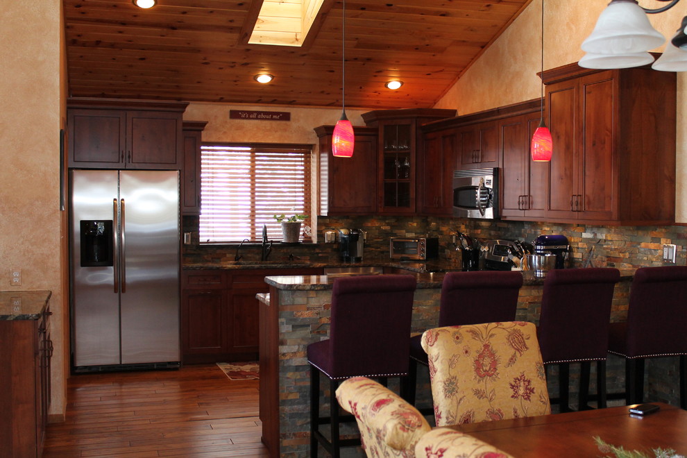 Foto på ett mellanstort medelhavsstil kök, med en undermonterad diskho, luckor med infälld panel, skåp i mellenmörkt trä, granitbänkskiva, flerfärgad stänkskydd, stänkskydd i stenkakel, rostfria vitvaror, mellanmörkt trägolv, en halv köksö och brunt golv