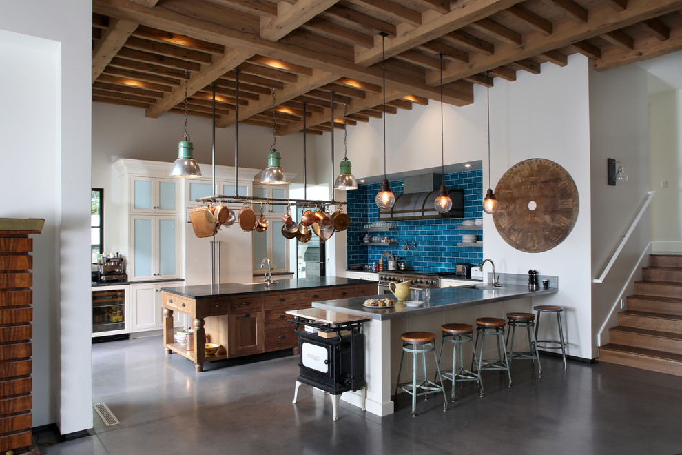 Mediterrane Küche in U-Form mit Glasfronten, Küchenrückwand in Blau, Rückwand aus Metrofliesen, Elektrogeräten mit Frontblende, Betonboden, weißen Schränken und zwei Kücheninseln in Boise