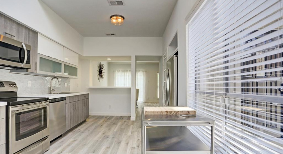 Exempel på ett litet retro vit linjärt vitt kök och matrum, med en nedsänkt diskho, släta luckor, skåp i ljust trä, bänkskiva i kvarts, stänkskydd med metallisk yta, stänkskydd i glaskakel, rostfria vitvaror, klinkergolv i porslin, en halv köksö och beiget golv