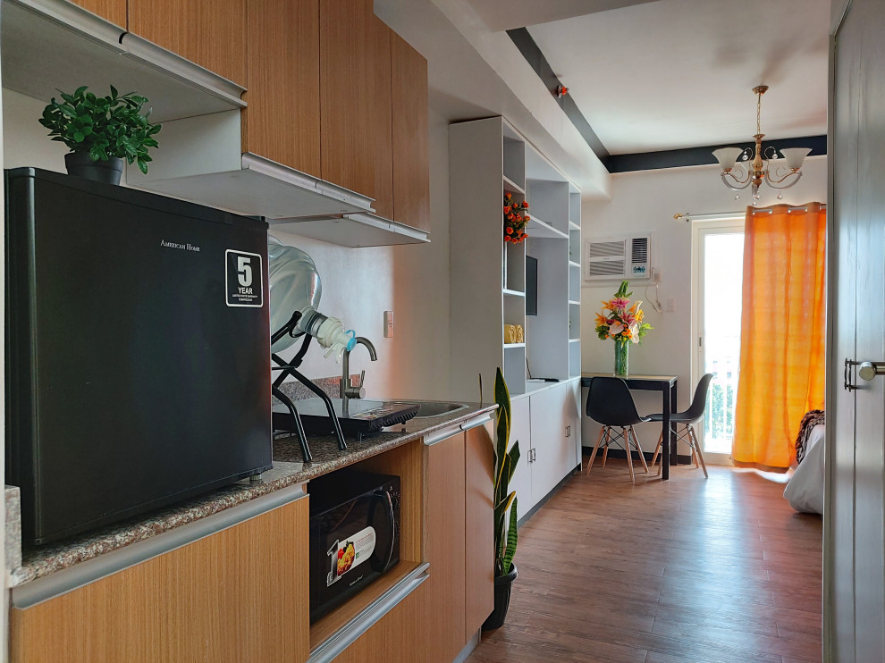 Esempio di una piccola cucina lineare minimalista con ante lisce, ante in legno chiaro, top in granito, paraspruzzi bianco, paraspruzzi con piastrelle di cemento, elettrodomestici neri, pavimento in vinile, pavimento marrone, top multicolore e soffitto ribassato