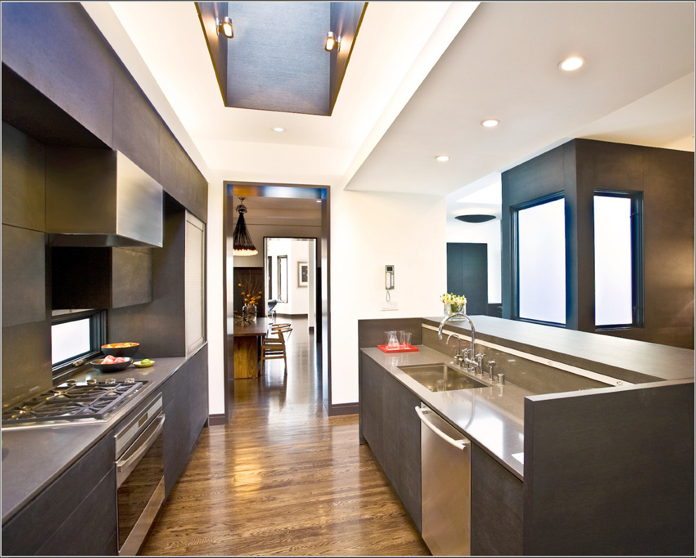 Ejemplo de cocina contemporánea con armarios con paneles lisos, puertas de armario de madera en tonos medios, suelo de madera oscura y una isla