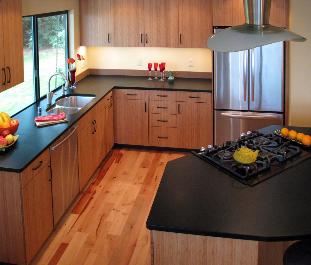 Cette photo montre une cuisine ouverte tendance en L et bois brun avec un évier encastré, un placard à porte plane, une crédence marron, un électroménager en acier inoxydable, un plan de travail en onyx, parquet clair, îlot et un sol beige.