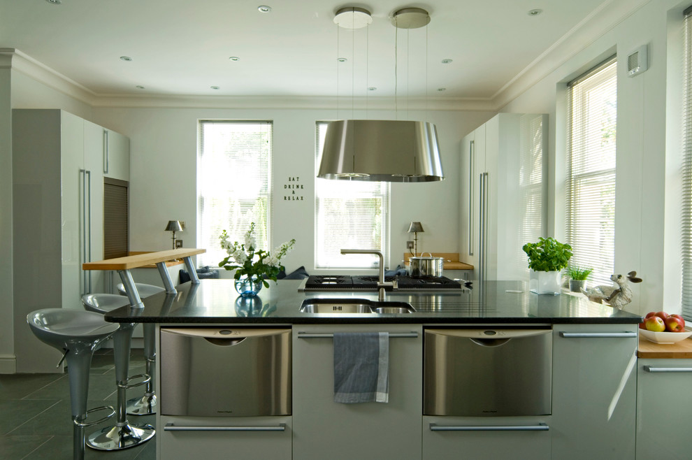 Photo of a contemporary kitchen/diner in Other with a submerged sink, flat-panel cabinets, grey cabinets, granite worktops, stainless steel appliances, slate flooring and an island.