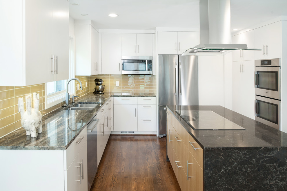 Inspiration for a mid-sized modern l-shaped medium tone wood floor enclosed kitchen remodel in Kansas City with flat-panel cabinets, light wood cabinets, granite countertops, yellow backsplash, glass tile backsplash, stainless steel appliances, an island and a drop-in sink