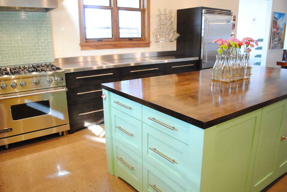 Immagine di una grande cucina design con ante lisce, ante in legno bruno e elettrodomestici in acciaio inossidabile