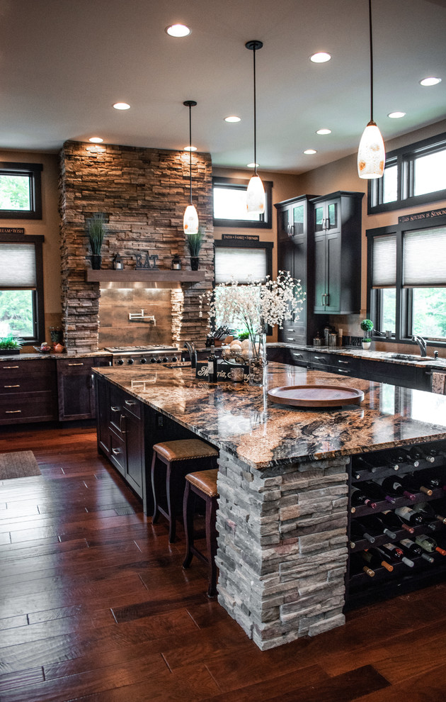 Réalisation d'une cuisine ouverte tradition en U et bois foncé avec un évier encastré, un placard à porte shaker, un plan de travail en granite, une crédence beige, une crédence en carreau de porcelaine, un électroménager en acier inoxydable, un sol en bois brun, îlot, un sol marron et un plan de travail multicolore.