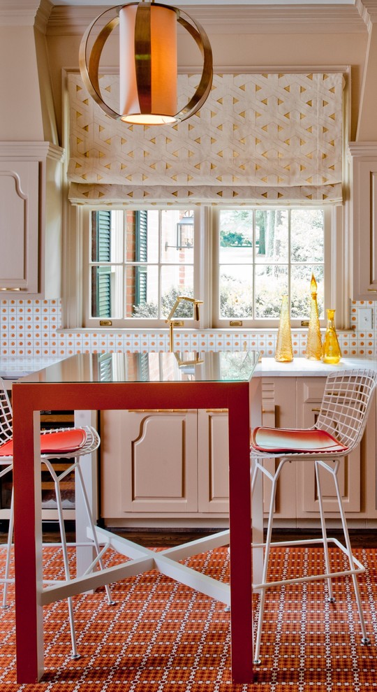 На фото: кухня в стиле неоклассика (современная классика) с обеденным столом, фасадами с выступающей филенкой, бежевыми фасадами и разноцветным фартуком