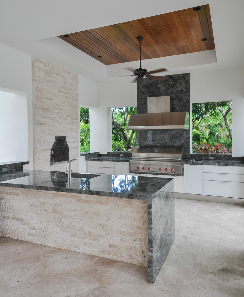 Photo of a contemporary u-shaped kitchen in Miami with flat-panel cabinets, white cabinets, grey splashback, stone tiled splashback and stainless steel appliances.
