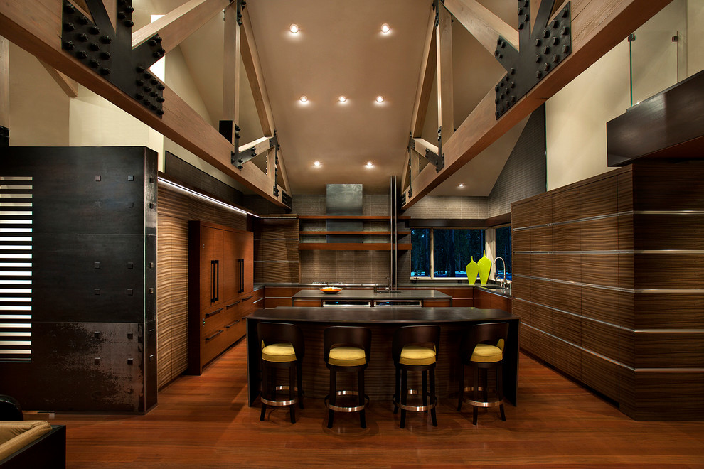 This is an example of a large contemporary u-shaped kitchen in Sacramento with dark wood cabinets, beige splashback, integrated appliances, medium hardwood flooring, multiple islands and brown floors.