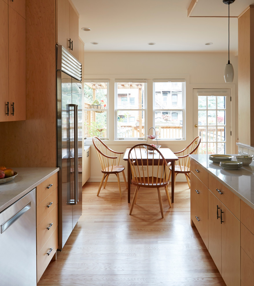 Example of a large minimalist l-shaped light wood floor and brown floor eat-in kitchen design in Chicago with a single-bowl sink, flat-panel cabinets, light wood cabinets, glass countertops, gray backsplash, glass tile backsplash, stainless steel appliances and an island