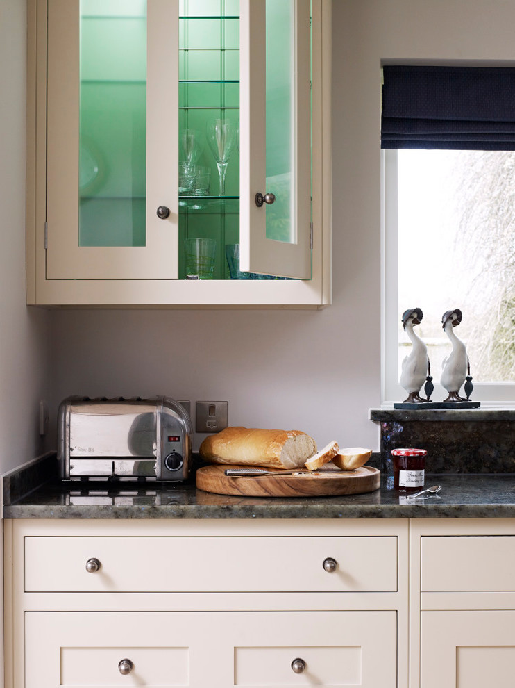 Inredning av ett modernt stort kök med öppen planlösning, med en integrerad diskho, skåp i shakerstil, vita skåp, granitbänkskiva, rostfria vitvaror och en köksö