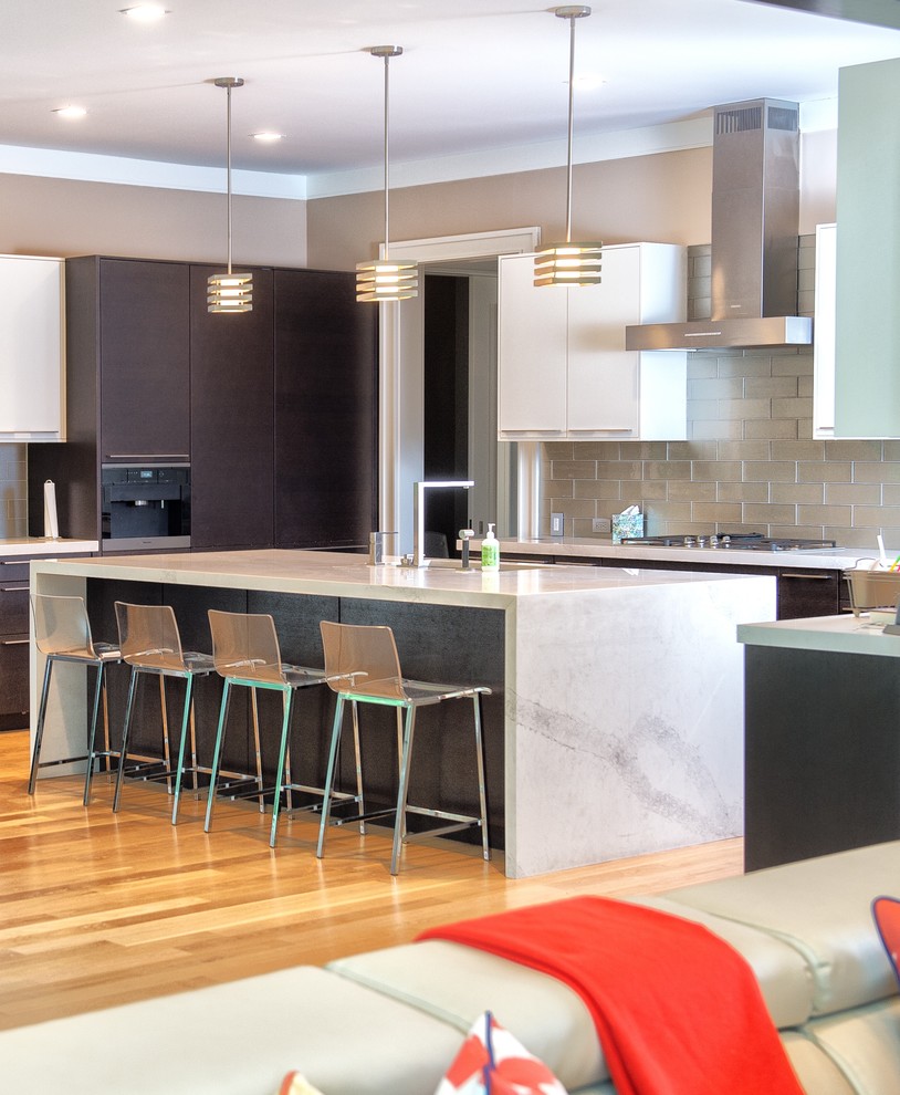 Example of a large minimalist l-shaped light wood floor and brown floor open concept kitchen design in New York with an undermount sink, flat-panel cabinets, brown cabinets, marble countertops, gray backsplash, metal backsplash, paneled appliances, an island and gray countertops