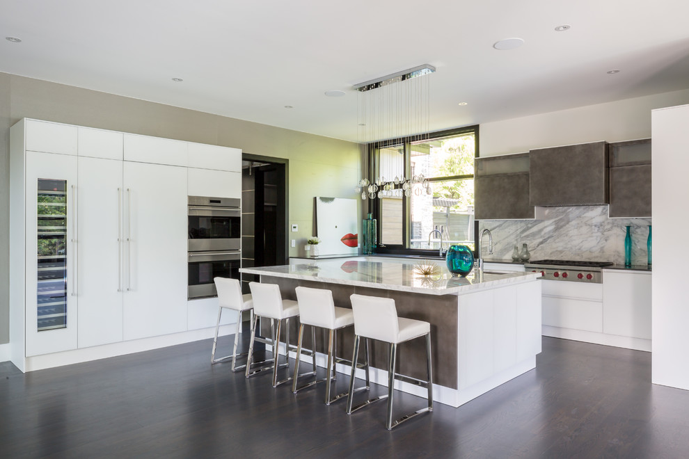 Trendy l-shaped dark wood floor open concept kitchen photo in Toronto with an undermount sink, flat-panel cabinets, white cabinets, marble countertops, white backsplash, paneled appliances and an island