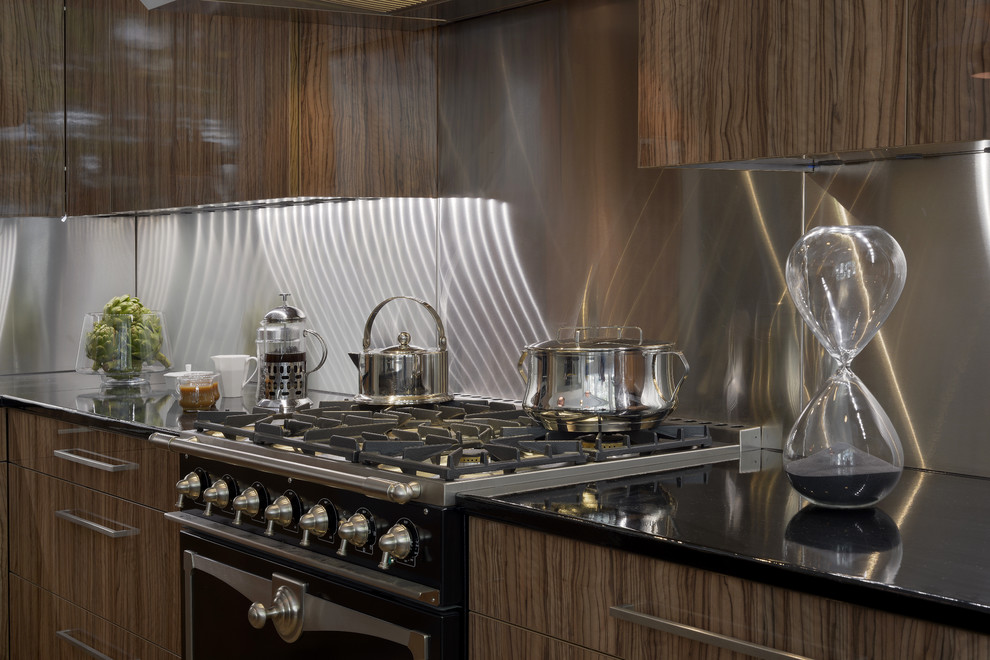 Esempio di una grande cucina design con lavello sottopiano, ante lisce, ante in legno scuro, paraspruzzi a effetto metallico, elettrodomestici in acciaio inossidabile e parquet chiaro