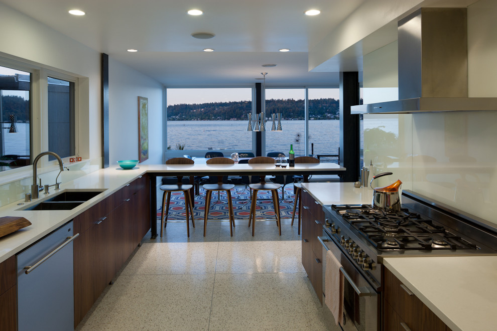 Example of a trendy galley cork floor and beige floor eat-in kitchen design in Seattle with a double-bowl sink, flat-panel cabinets, dark wood cabinets, granite countertops, white backsplash, no island, glass sheet backsplash and stainless steel appliances