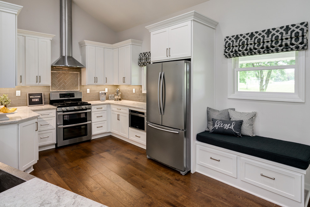 Huge minimalist u-shaped dark wood floor and brown floor open concept kitchen photo in Columbus with a farmhouse sink, shaker cabinets, white cabinets, granite countertops, beige backsplash, subway tile backsplash, stainless steel appliances, an island and white countertops
