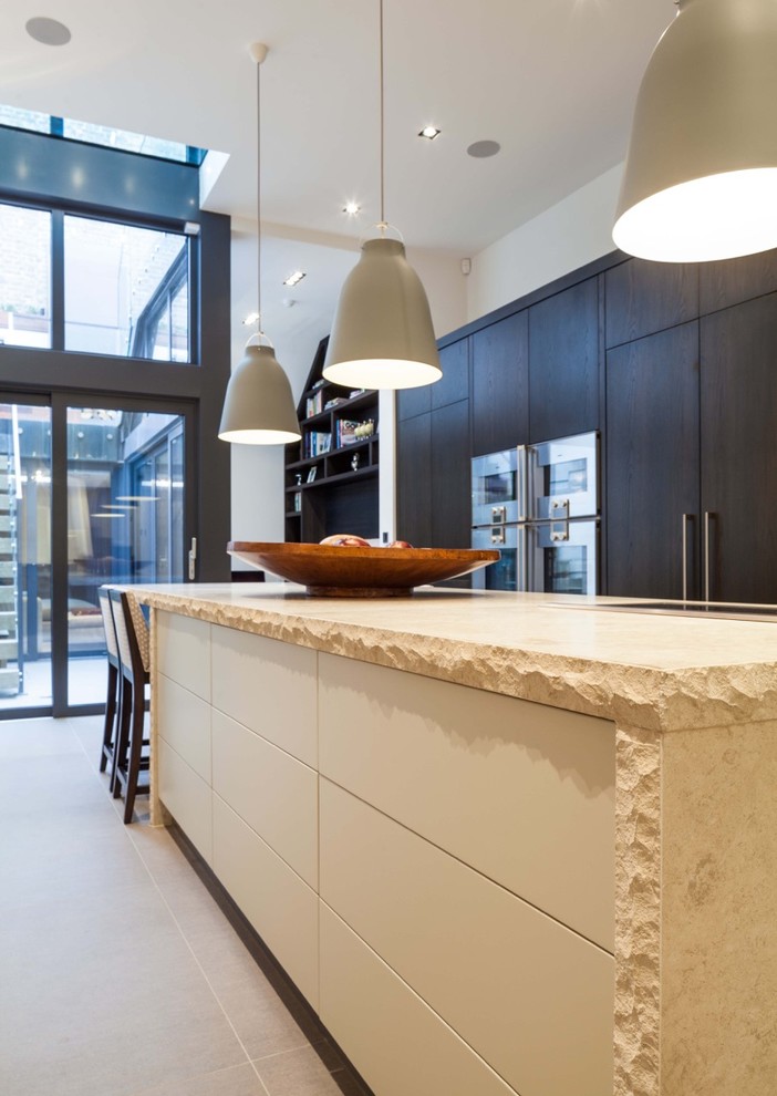 ロンドンにある高級な広いコンテンポラリースタイルのおしゃれなキッチン (一体型シンク、濃色木目調キャビネット、ライムストーンカウンター、白いキッチンパネル、ガラス板のキッチンパネル、シルバーの調理設備) の写真