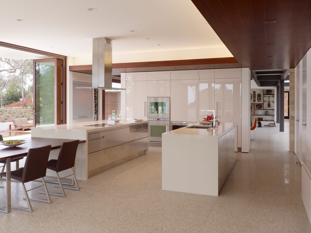 На фото: глянцевая кухня в стиле модернизм с обеденным столом, плоскими фасадами, белыми фасадами и белой техникой с