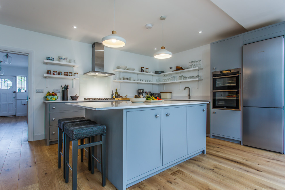Inspiration for a medium sized classic l-shaped open plan kitchen in Sussex with flat-panel cabinets, quartz worktops, an island and white worktops.
