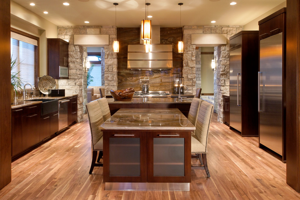 Example of a huge eclectic medium tone wood floor eat-in kitchen design in Omaha with a farmhouse sink, flat-panel cabinets, dark wood cabinets, granite countertops, stainless steel appliances and an island