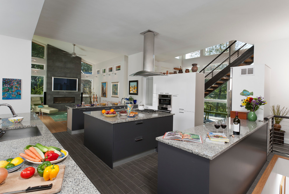 Esempio di una grande cucina abitabile minimalista con ante grigie, top in granito e 2 o più isole