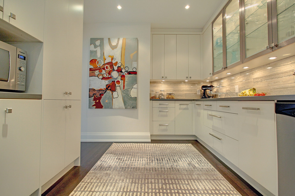 Cette image montre une cuisine parallèle design avec un placard à porte plane, un électroménager en acier inoxydable, parquet foncé et une crédence en pierre calcaire.