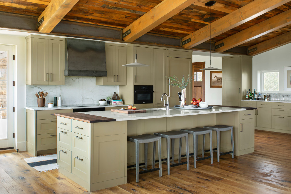 This is an example of an expansive rustic l-shaped kitchen in Denver with shaker cabinets, green cabinets, white splashback, integrated appliances, light hardwood flooring, an island, brown floors, white worktops and a wood ceiling.